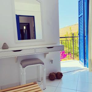 a bathroom with a vanity with a mirror and a stool at Spanos Apartments in Agios Petros