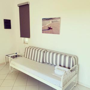 a white bench in a room with a picture on the wall at Spanos Apartments in Agios Petros