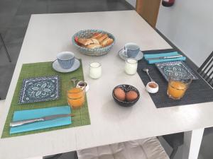 a table with eggs and cups and a bowl of food at Casa Sol y Luz - casa rural in Carboneras