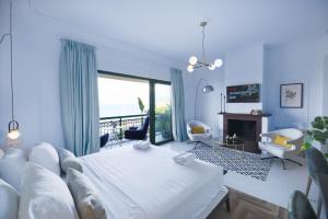 a bedroom with a white bed and a fireplace at The Well View in Preveza