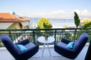 a balcony with two chairs and a table and the ocean at The Well View in Preveza