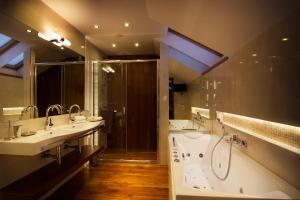 a bathroom with a sink, mirror, and bathtub at City Residence Apartment Hotel in Košice