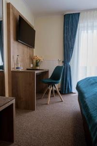 a bedroom with a bed and a desk and a chair at Gasthof Hotel Drei Tannen Altdorf in Altdorf