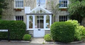una puerta blanca en una casa con arbustos en The Laurels At Inchbrook, en Stroud