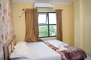 a bed in a room with a window at Hotel Royal Sunview in Digha