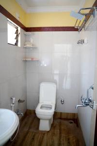 een badkamer met een wit toilet en een wastafel bij Hotel Royal Sunview in Digha