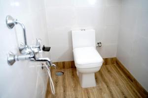- une salle de bains avec des toilettes blanches dans une cabine dans l'établissement Hotel Royal Sunview, à Digha