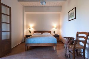 a bedroom with a bed and a chair at Kalamitsi Hotel in Kardamyli