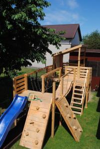 a wooden play set with a slide and a slideintend at Willa Jaskółka in Władysławowo