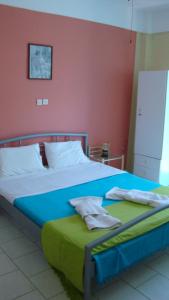 a bedroom with a large bed with a blue blanket at Dionisis Apartments in Ayia Evfimia