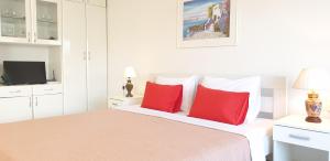 a bedroom with a bed with two red pillows at The White Apartment in Ohrid