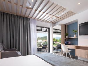 een slaapkamer met een bed en een tv en een woonkamer bij Sky Luxury Suites in Sarti