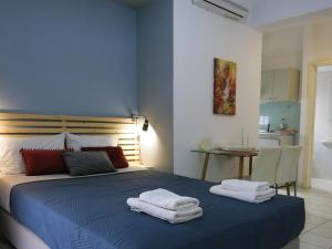 - une chambre avec un lit bleu et des serviettes dans l'établissement Halepa Apartments, à La Canée