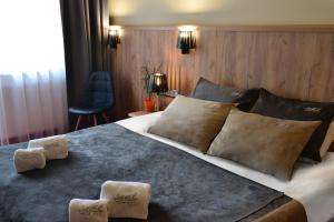 una camera da letto con un grande letto con cuscini sopra di Hotel Agit Congress&Spa a Lublino