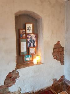 un nicho en una pared con cuadros y velas en Pilegrimsherberge InnomHaug, en Jessheim