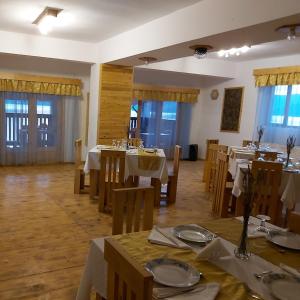 a dining room with tables and chairs and windows at CONACUL SARBESC in Sviniţa