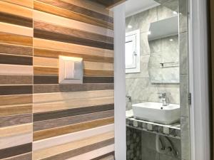 a bathroom with wooden walls and a sink at Skoulidis Family Apartments in Nea Vrasna +29 photos