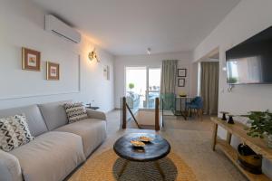 a living room with a couch and a table at The Well View in Preveza