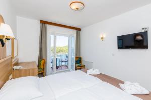 Habitación de hotel con cama y balcón en Villa Paradiso 2, en Dubrovnik