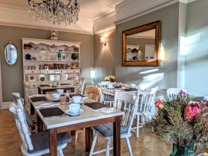 jadalnia ze stołami, krzesłami i lustrem w obiekcie Alexander Lodge Guest House w Bournemouth