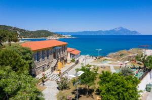 een gebouw met een rood dak naast het water bij Sky Luxury Suites in Sarti