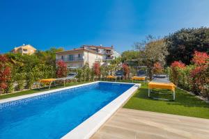 una piscina en un patio con sillas alrededor en Villa Antonela, en Malinska