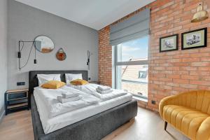 um quarto com uma cama grande e uma parede de tijolos em Comfort Apartments Granaria em Gdansk