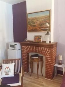 uma sala de estar com uma lareira de tijolos e uma mesa em Quai de l ' Arnette em Mazamet