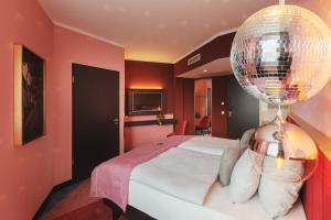 um quarto com uma cama grande e uma bola de discoteca em the niu Loco em Munique