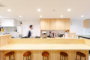 a kitchen with a wooden counter top and stools at Hanke Sandwich & Inn in Sapporo