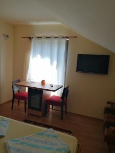 a room with a table and chairs and a window at Pensiunea Armand in Supuru de Jos