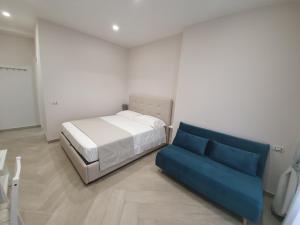 ein Schlafzimmer mit einem Bett und einem blauen Sofa in der Unterkunft Dimora Costantino in Neapel