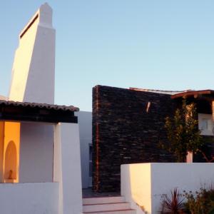 een kerk en een gebouw met een wit hek bij Monte Falperras in Mourão