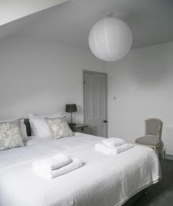 a bedroom with a white bed with towels on it at Oswald House deluxe 3 bedroom apartment in Harrogate