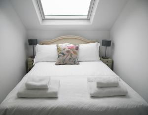 哈羅蓋特的住宿－Oswald House deluxe 3 bedroom apartment，卧室配有白色的床、两个枕头和窗户