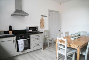 a kitchen with a table and a stove top oven at Oswald House deluxe 3 bedroom apartment in Harrogate
