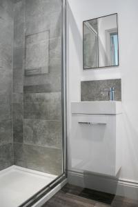 哈羅蓋特的住宿－Oswald House deluxe 3 bedroom apartment，带淋浴、盥洗盆和镜子的浴室
