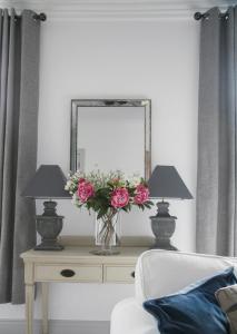 a vase of flowers on a table with two lamps at Oswald House deluxe 3 bedroom apartment in Harrogate