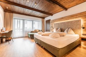 ein Schlafzimmer mit großem Bett und Schreibtisch in der Unterkunft Alpenlove - Adult SPA Hotel in Seefeld in Tirol