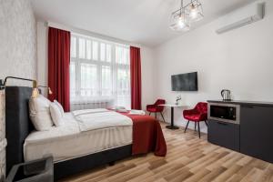 een slaapkamer met een bed, een bureau en een televisie bij Hotel Clariss in Balatonalmádi