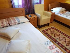 a hotel room with two beds and a chair at Cabana Corbu Băile Figa in Beclean +24 photos