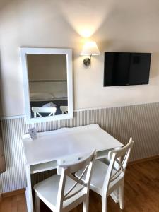 a white table and chairs in a room with a mirror at Relais Duomo Adelaide in Florence