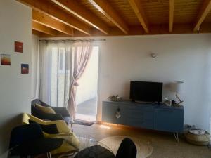 a living room with a tv and a window at La Petite Chaunière in Saint-Fulgent