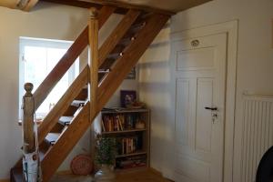 een houten trap in een kamer met een boekenplank bij Balancehaus Kohren-Sahlis, dein Kurhaus in Sachsen in Kohren-Sahlis
