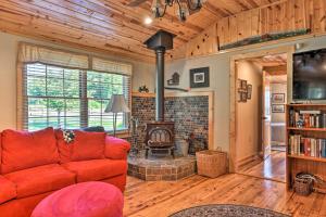 ein Wohnzimmer mit einem roten Sofa und einem Kamin in der Unterkunft Blue Ridge Parkway House with Mountain Scenery! in Glade Valley
