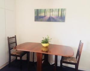 a wooden table with two chairs and a plant on it at Edge of Exmoor Garden Flat, dog friendly, sleeps 2 - 4 in East Anstey