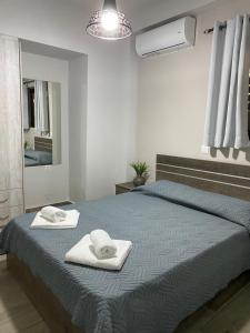 a bedroom with a bed with towels on it at Elena's Apartment in Panormos Rethymno