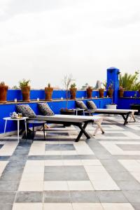 une rangée de bancs assis au-dessus d'un patio dans l'établissement Riad Goloboy, à Marrakech
