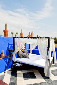 a bed with a canopy on a roof at Riad Goloboy in Marrakesh