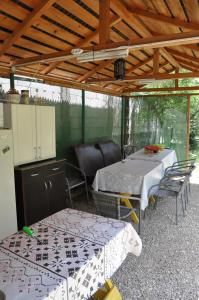 een patio met 2 tafels en stoelen onder een dak bij Pensiunea Rustic in Eforie Sud
